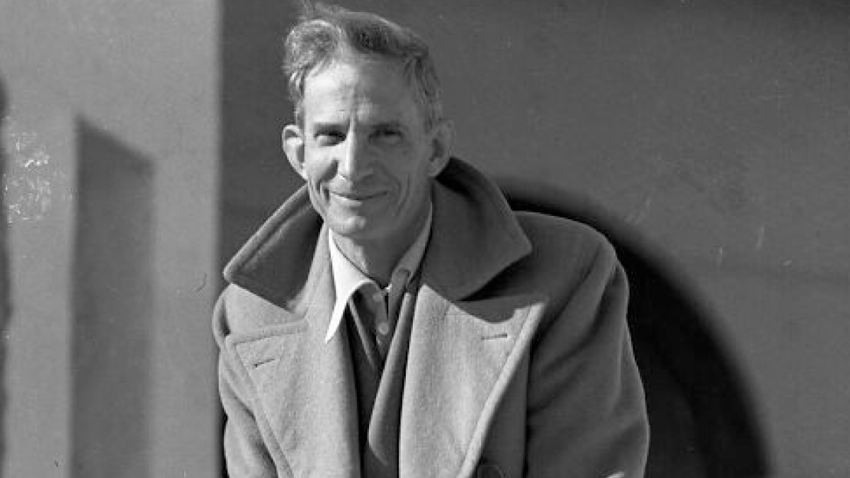 Black and white portrait of a man in a coat, representing historic moments in the birth of Vegas from 1905-1955.