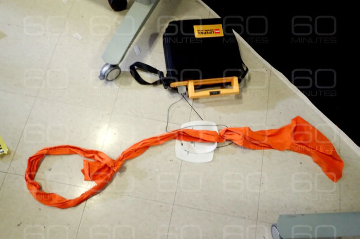 Orange fabric noose and black bag on jail floor, highlighting missing minutes in Epstein jail video doubts. Orange fabric noose and black bag on jail floor, highlighting missing minutes in Epstein jail video doubts.