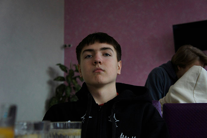 Teen boy with serious expression indoors, representing effects of lazy parenting turning kids into walking nightmares.