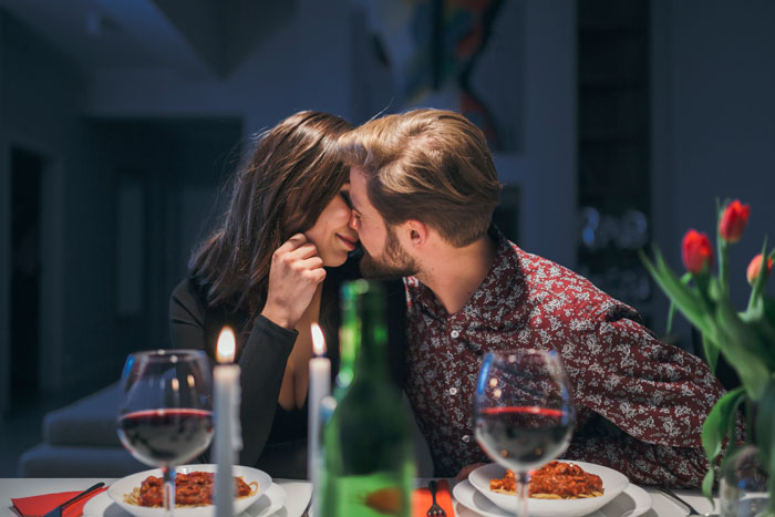 Couple sharing a tender moment over dinner, illustrating themes of betrayal and giving a taste of her own medicine in friendship conflicts. Couple sharing a tender moment over dinner, illustrating themes of betrayal and giving a taste of her own medicine in friendship conflicts.