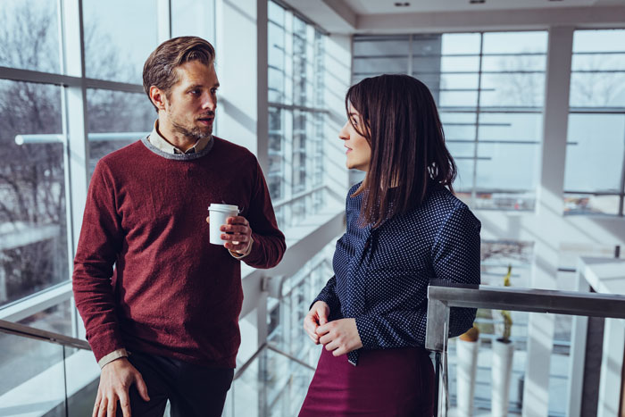 Two coworkers in a modern office having a serious conversation, illustrating a person calling obnoxious coworker's bluff. Two coworkers in a modern office having a serious conversation, illustrating a person calling obnoxious coworker's bluff.
