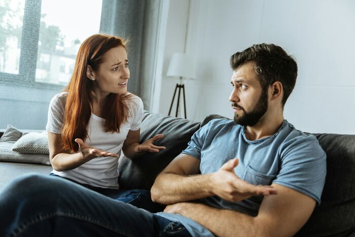 Fiance and non biological child having a serious conversation on a couch in a bright living room. Fiance and non biological child having a serious conversation on a couch in a bright living room.