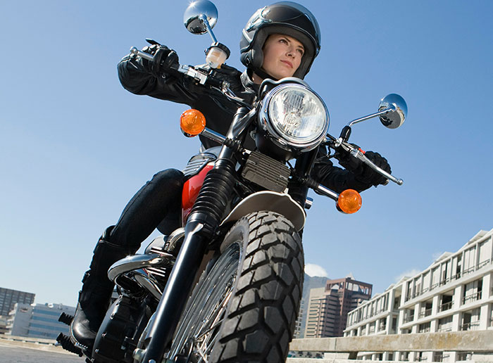Teen wearing helmet rides motorcycle in city, capturing a moment of independence and adventure on urban streets. Teen wearing helmet rides motorcycle in city, capturing a moment of independence and adventure on urban streets.