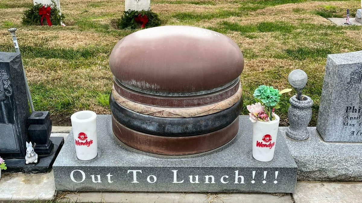 Cemetery tombstone shaped like a hamburger with Wendy's cups and Out To Lunch inscription showing awful taste but great e*******n.