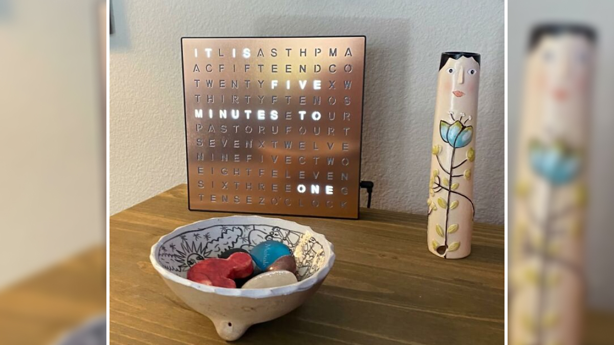 Modern word clock and decorative ceramic items on a wooden surface showcasing useful decor items that earn their keep.