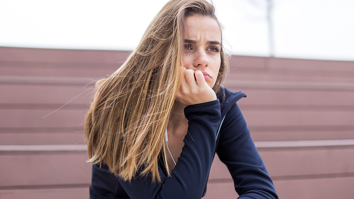Young bride looking upset and contemplative, reflecting on being cut off from key wedding plans by her mom.
