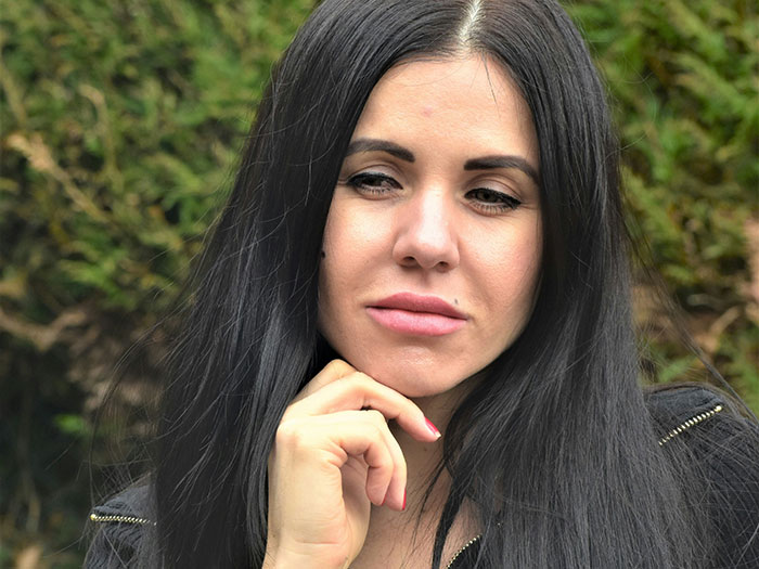 Young woman with long black hair looking thoughtful outdoors reflecting on kindness after bullying at a party seat incident. Young woman with long black hair looking thoughtful outdoors reflecting on kindness after bullying at a party seat incident.