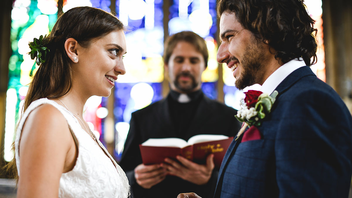 Bride and groom during wedding vows with a confused bride reacting to groom mentioning his exu2019s name in a church ceremony