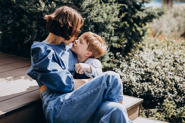 Pregnant lady sitting outdoors with her young son, sharing a tender moment amid feelings of neglect and family tension. Pregnant lady sitting outdoors with her young son, sharing a tender moment amid feelings of neglect and family tension.