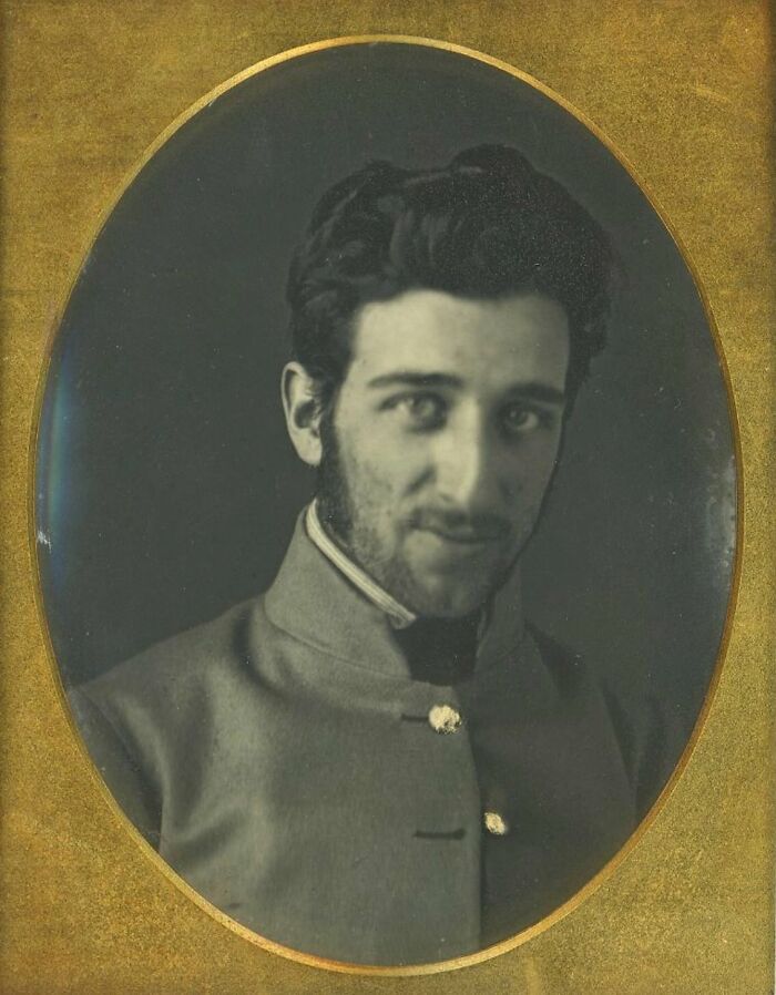 Portrait of a handsome Victorian man with dark hair and facial hair in a vintage photograph frame.