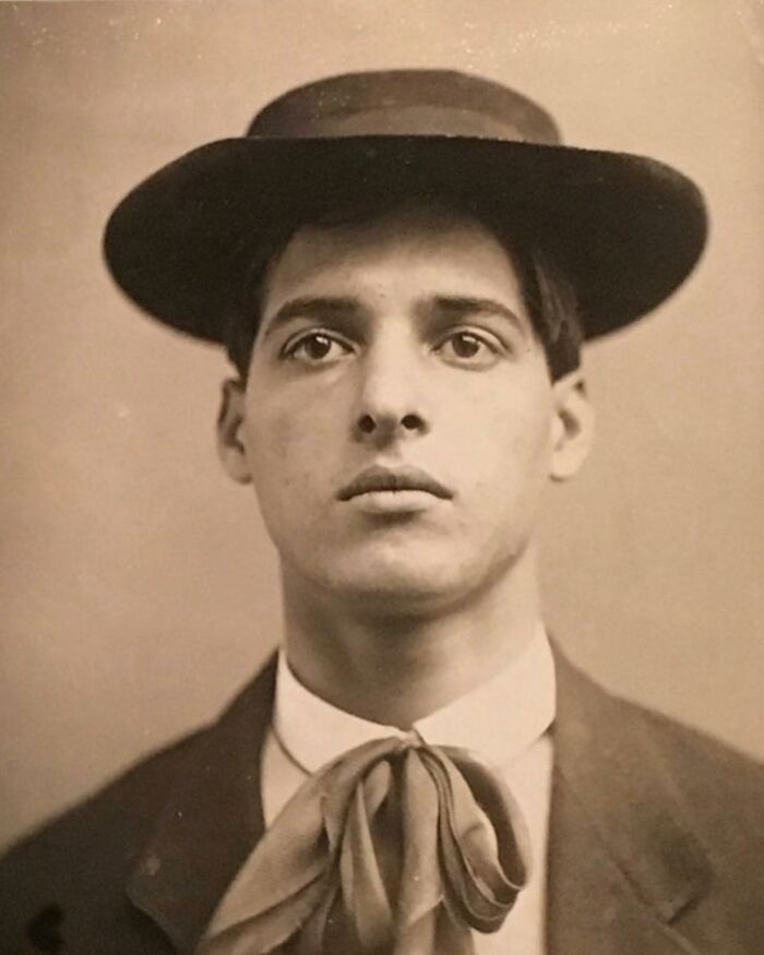 Young Victorian man in vintage attire with wide-brimmed hat and necktie, a handsome Victorian portrait.
