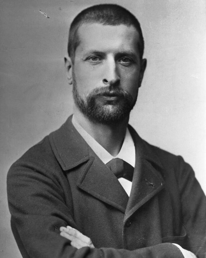 Victorian man with beard and short hair wearing a formal coat, embodying handsome Victorian men style and charm.