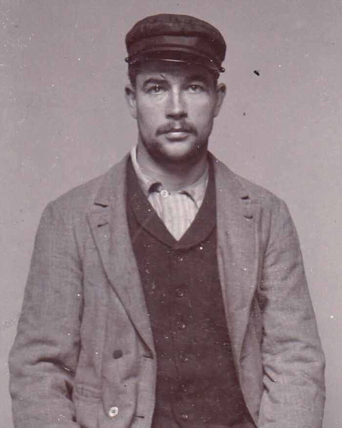 Victorian man wearing cap and layered clothing, representing the charm of handsome Victorian men from historical photos.