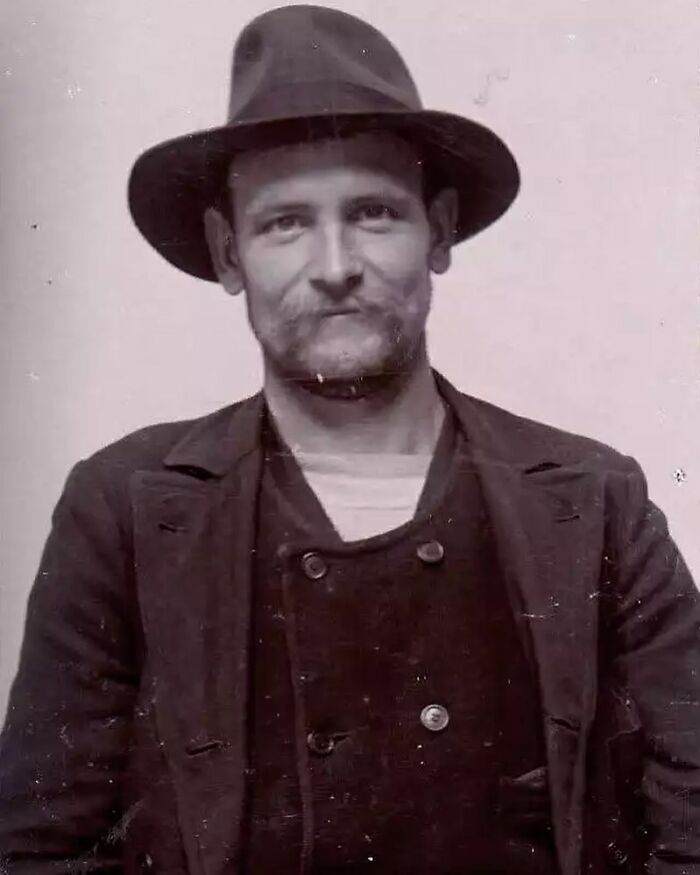 Black and white portrait of a handsome Victorian man wearing a hat and layered coat, embodying Victorian era style.