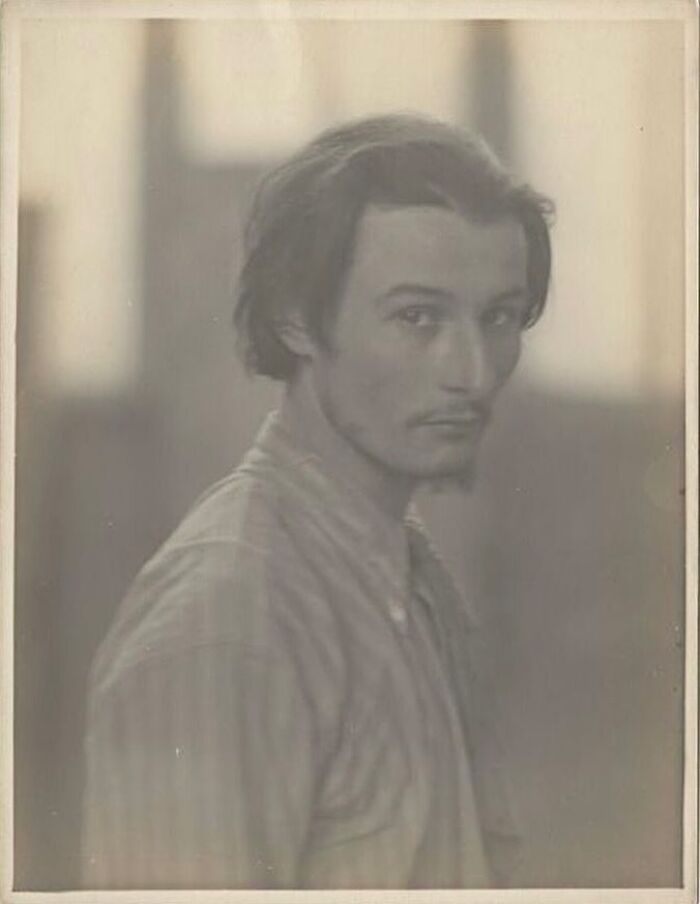 Vintage portrait of a handsome Victorian man with a mustache, wearing a striped shirt, looking thoughtfully at the camera.