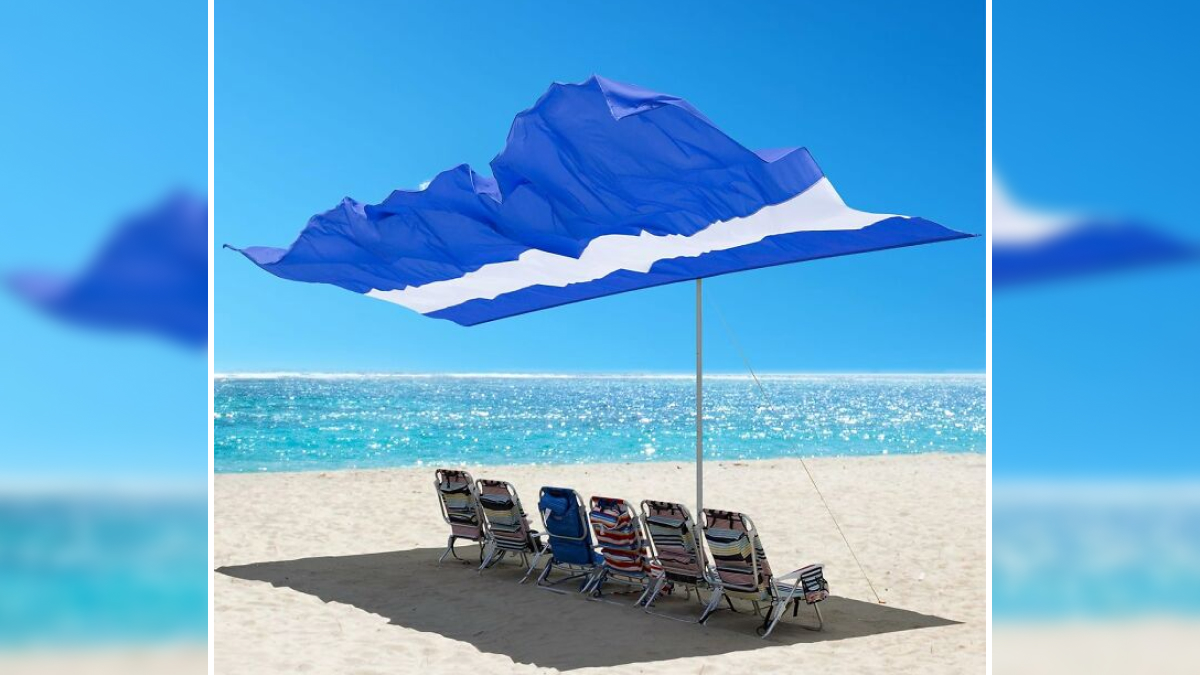 Beach chairs under a large blue and white umbrella providing shade on a sunny day, demonstrating heatwave hacks.