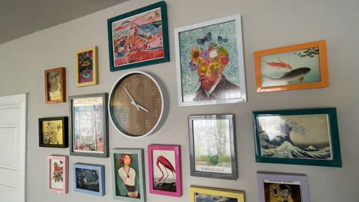Wall decorated with framed art and a clock, demonstrating genius hacks for hiding ugly stuff in home decor.
