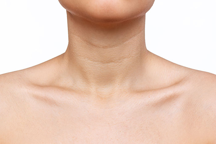 Close-up of a person's neck and collarbone area showing natural skin texture and surprising body quirks in detail.