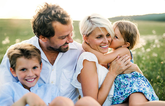 Happy family outdoors with husband, wife, and children sharing a moment after marriage therapy discussions. Happy family outdoors with husband, wife, and children sharing a moment after marriage therapy discussions.