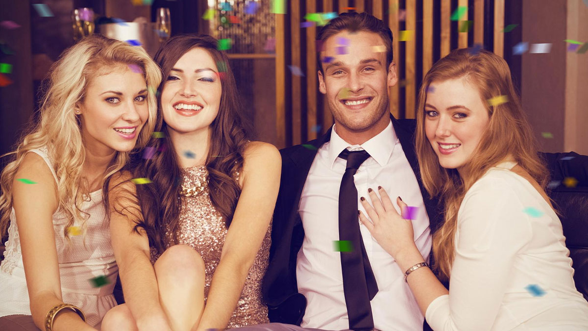 Group of friends celebrating with confetti, highlighting surprise visitor and pregnancy during husbandu2019s boys weekend.