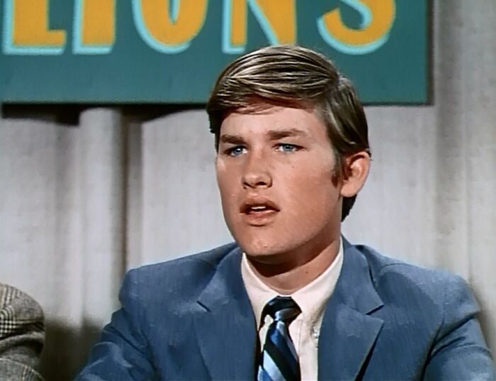 Young male actor in a vintage suit and tie, representing iconic actors who were the ultimate heartthrobs of their time.