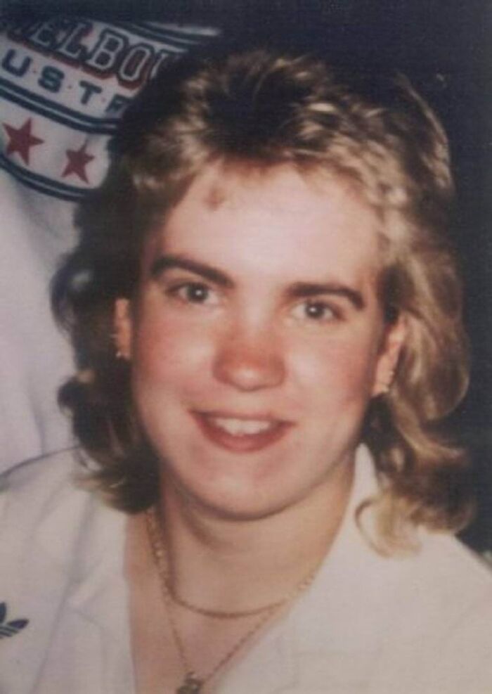 Young woman with a 90s hairstyle smiling in a close-up photo related to chilling disappearances from the 90s.
