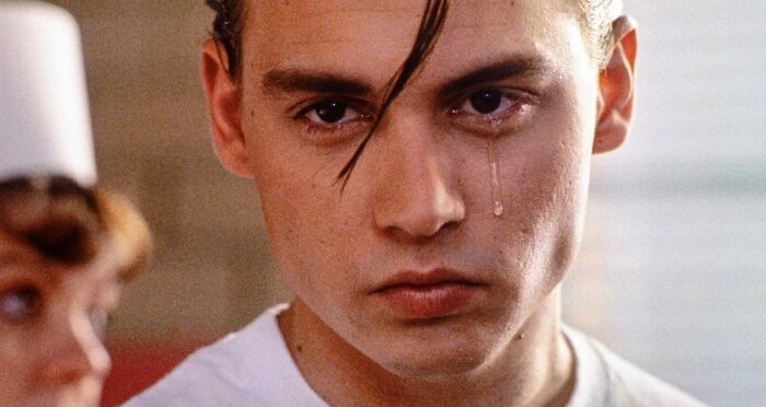 Close-up of a male actor with a tear on his cheek, showcasing iconic photos of ultimate heartthrobs from their time.