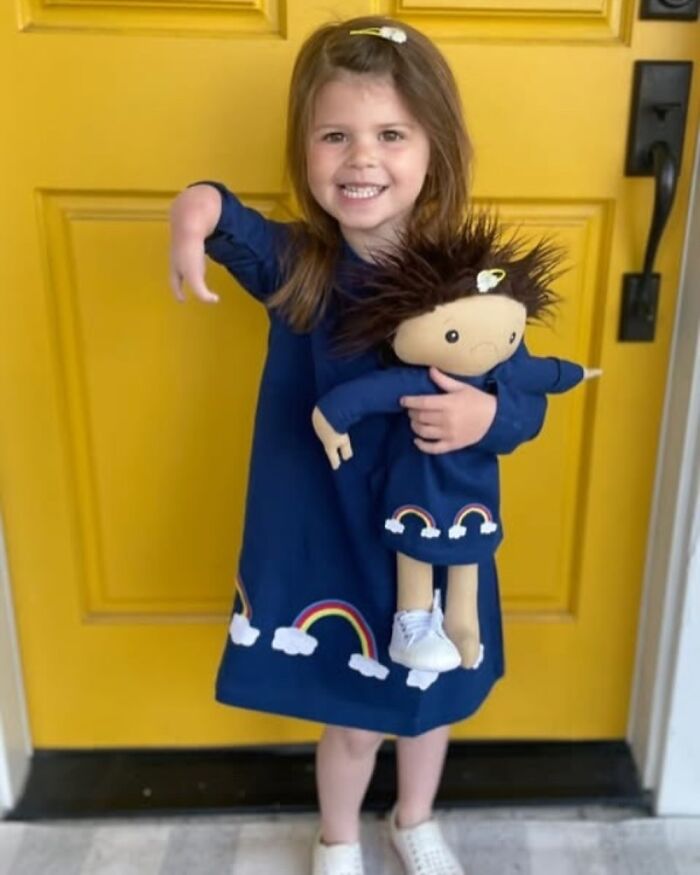 Young girl holding a custom doll designed to represent her rare health condition and unique needs.