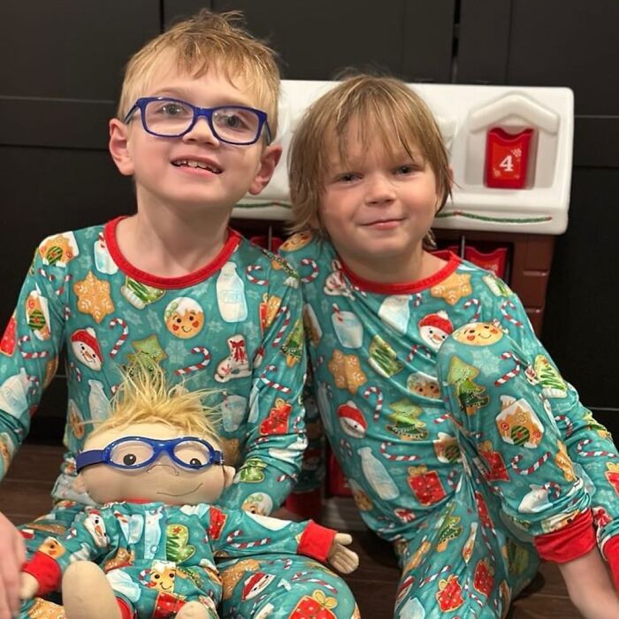 Two children in matching pajamas with a custom doll representing rare health conditions and individual needs.