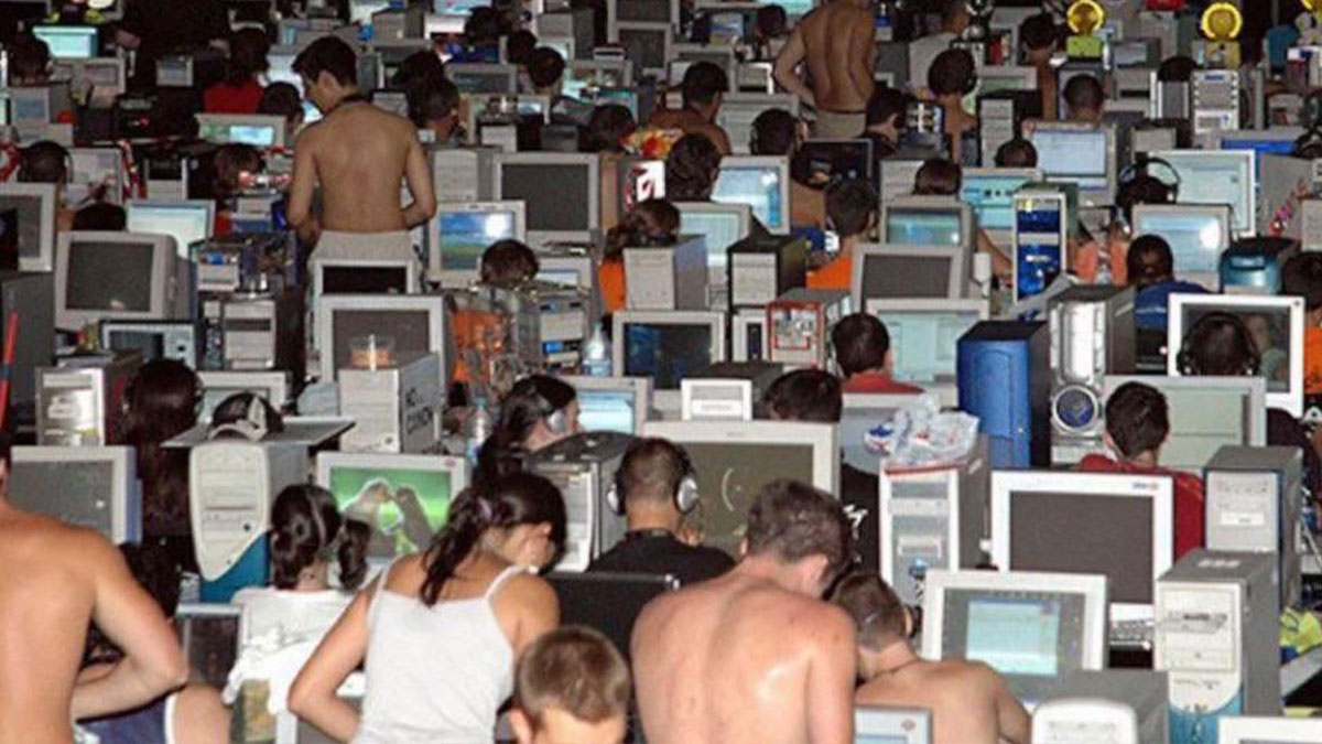 Large room filled with people using old desktop computers showcasing unfamiliar parts of history in technology culture.