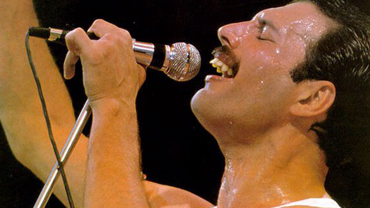 Man passionately singing into a microphone on stage, captured in a powerful moment of live performance facts.