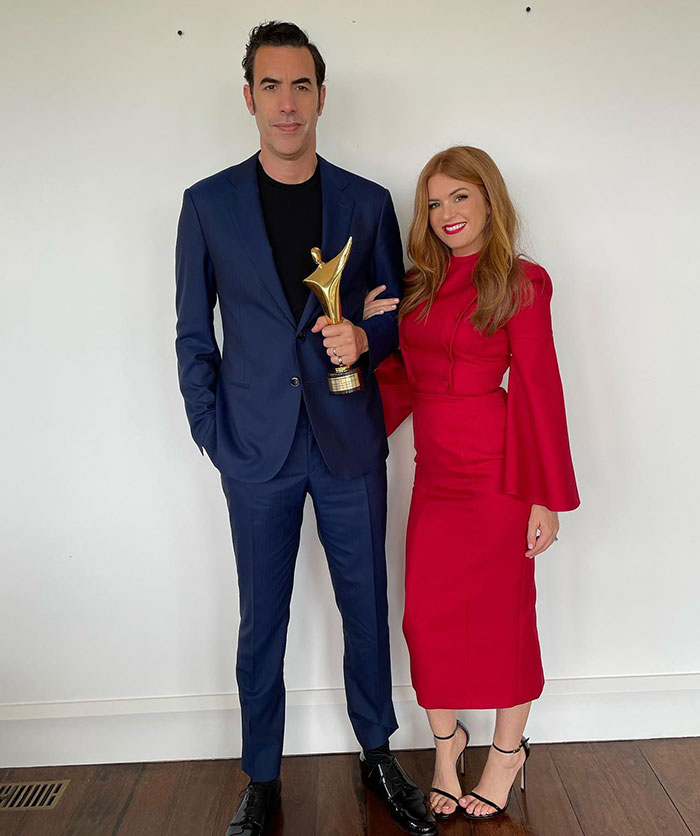 Isla Fisher and Sasha Baron Cohen posing indoors, with Isla in a red dress, amid news of tough couple of years. Isla Fisher and Sasha Baron Cohen posing indoors, with Isla in a red dress, amid news of tough couple of years.