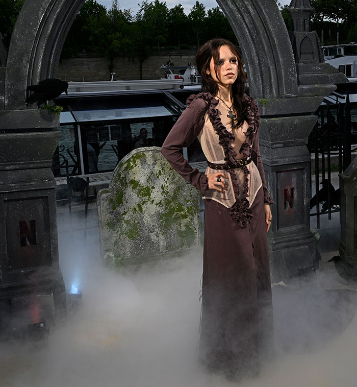 Jenna Ortega posing in a gothic styled dress at a foggy cemetery scene reflecting Wednesday looks fashion. Jenna Ortega posing in a gothic styled dress at a foggy cemetery scene reflecting Wednesday looks fashion.