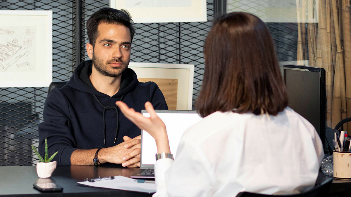 Man attentively listening to woman during job interview highlighting interview red flags for toxic workplace signs.