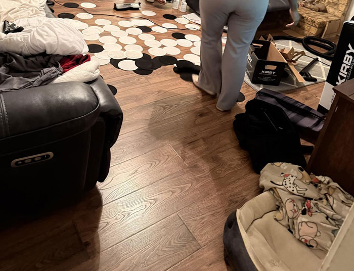 Person walking away in cluttered room with vacuum cleaner boxes and scattered items, showing frustration with villainous salespeople.