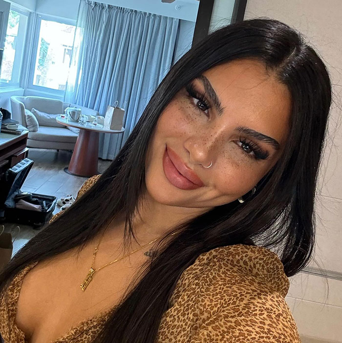 Young woman with styled eyebrows and defined lips representing Love Island face trend and filler concerns indoors. Young woman with styled eyebrows and defined lips representing Love Island face trend and filler concerns indoors.
