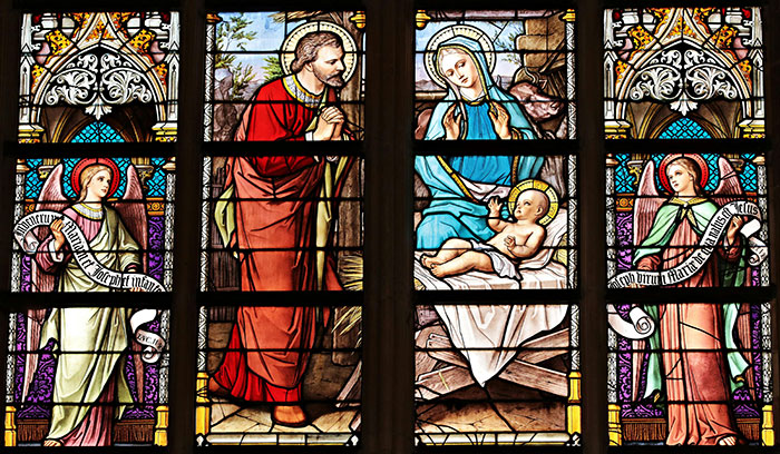 Stained glass window depicting nativity scene with Mary, baby Jesus, Joseph, and two angels in vivid colors. Stained glass window depicting nativity scene with Mary, baby Jesus, Joseph, and two angels in vivid colors.