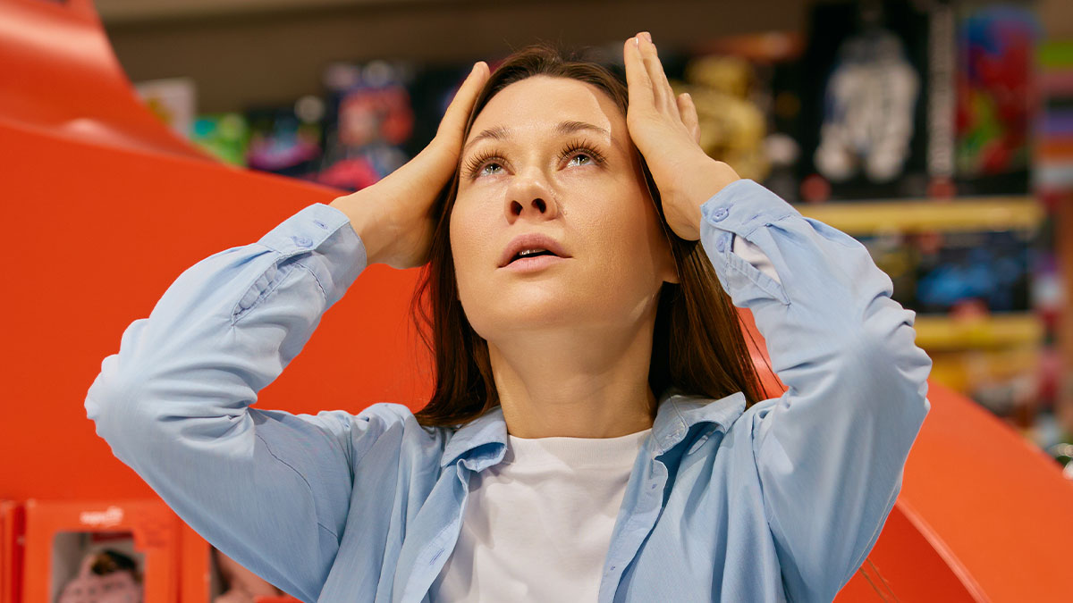 Woman stressed at work holding her head in frustration after manager calls her useless and gets schooled.