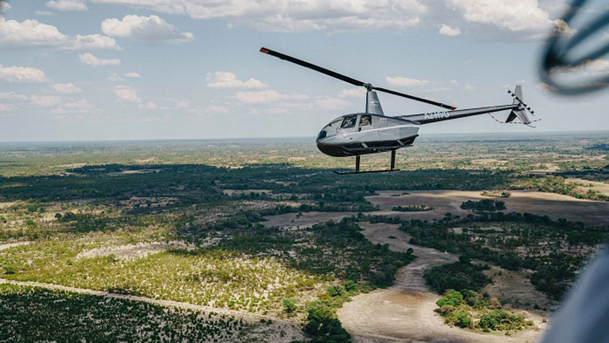 Helicopter flying over the lush Okavango Delta, showcasing the breathtaking landscape of this beautiful natural area.