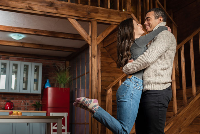 Couple embracing happily in cozy wooden home, highlighting woman saying no to future MIL’s temporary stay before marriage. Couple embracing happily in cozy wooden home, highlighting woman saying no to future MIL’s temporary stay before marriage.