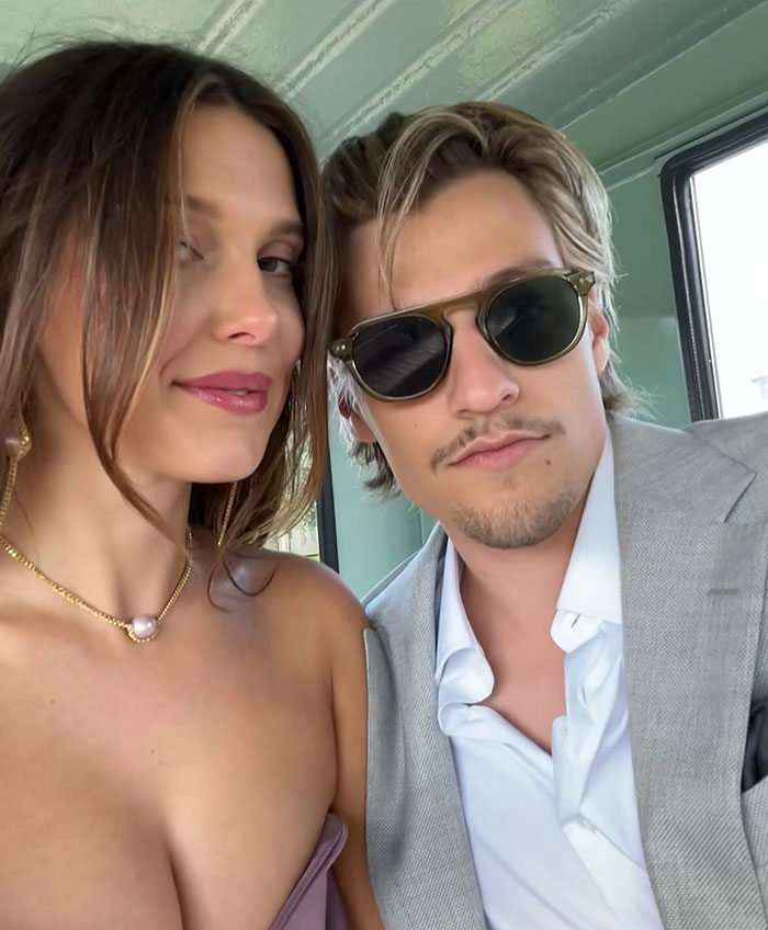 Young woman and man posing for a selfie indoors, linked to news about Millie Bobby Brown adopting a baby at 21. Young woman and man posing for a selfie indoors, linked to news about Millie Bobby Brown adopting a baby at 21.