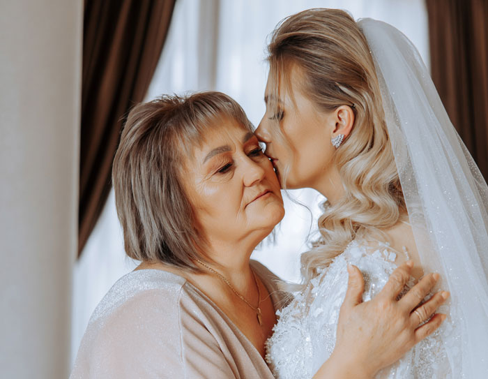 Bride and her mom sharing an emotional moment with the mom threatening to wear a white gown to the wedding event. Bride and her mom sharing an emotional moment with the mom threatening to wear a white gown to the wedding event.