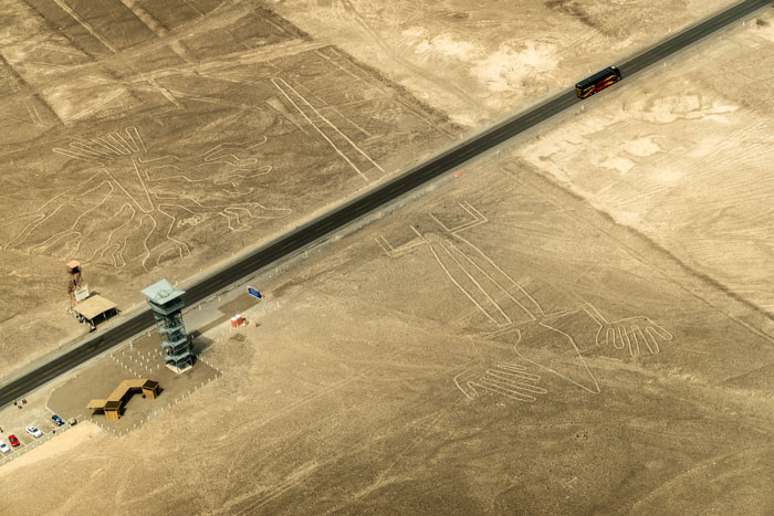 Aerial view of ancient geoglyphs in desert landscape with a road and observation tower, highlighting AI geoglyph discoveries. Aerial view of ancient geoglyphs in desert landscape with a road and observation tower, highlighting AI geoglyph discoveries.