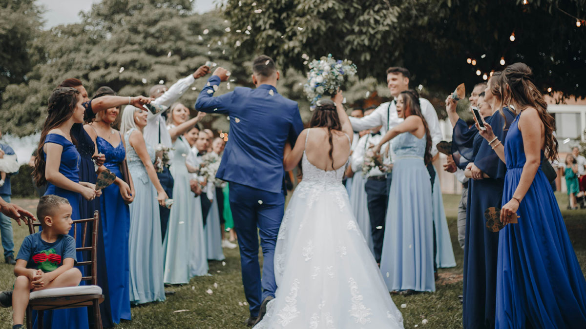 Bride and groom celebrating at wedding with guests throwing confetti, highlighting flaky woman missing friendu2019s wedding incident.