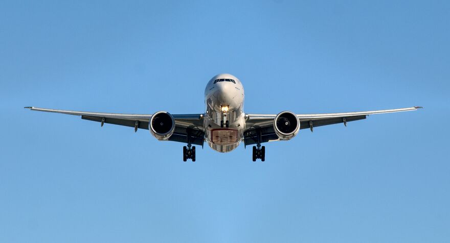 Commercial airplane landing against clear blue sky, illustrating home alone vibes at airport with child left behind. Commercial airplane landing against clear blue sky, illustrating home alone vibes at airport with child left behind.