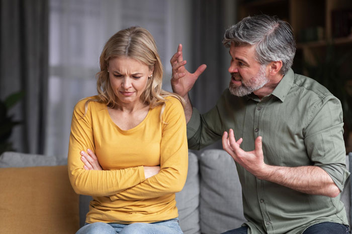 Middle-aged man angrily gesturing at upset woman, illustrating parents forcing pay expensive rent argument at home.