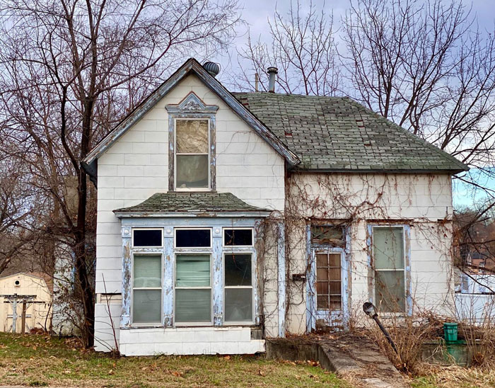 Old worn-down house with peeling paint and boarded windows, illustrating parents forcing pay expensive rent struggles. Old worn-down house with peeling paint and boarded windows, illustrating parents forcing pay expensive rent struggles.