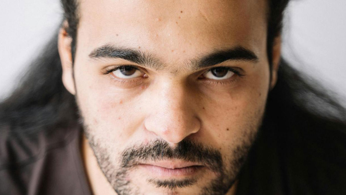 Close-up of a man with intense eyes and a serious expression illustrating traits of a psychopath in a portrait.