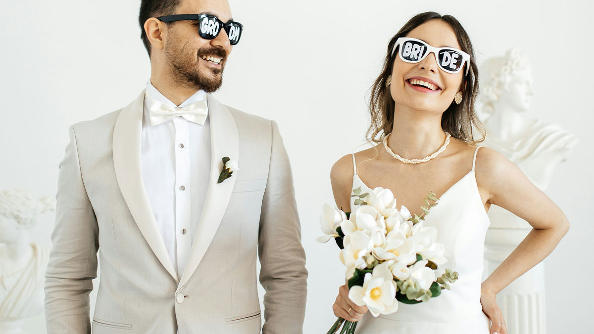 Bride and groom wearing playful sunglasses at their wedding, sharing moments of unhinged wedding spends celebration.