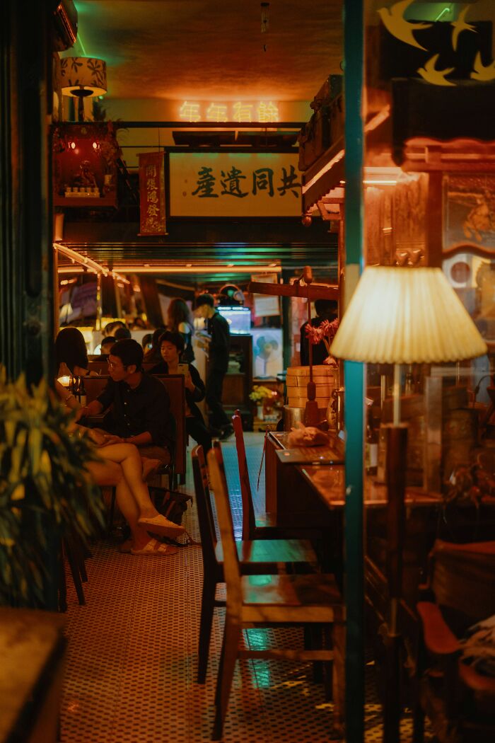 Dimly lit vintage cafe with patrons seated and warm ambient lighting, capturing moments people decided to leave abruptly.